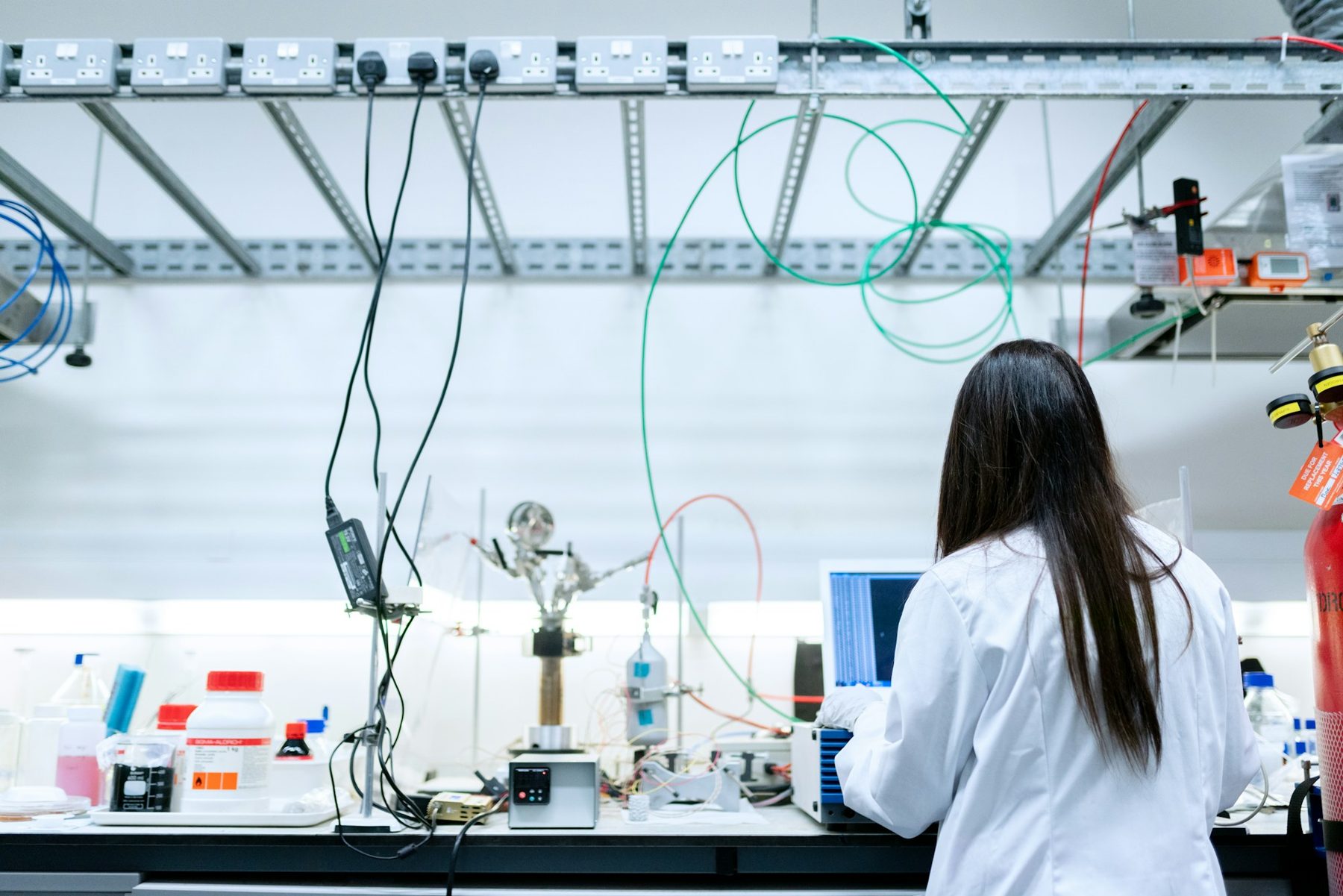 A scientist working at a laptop in a laboratory