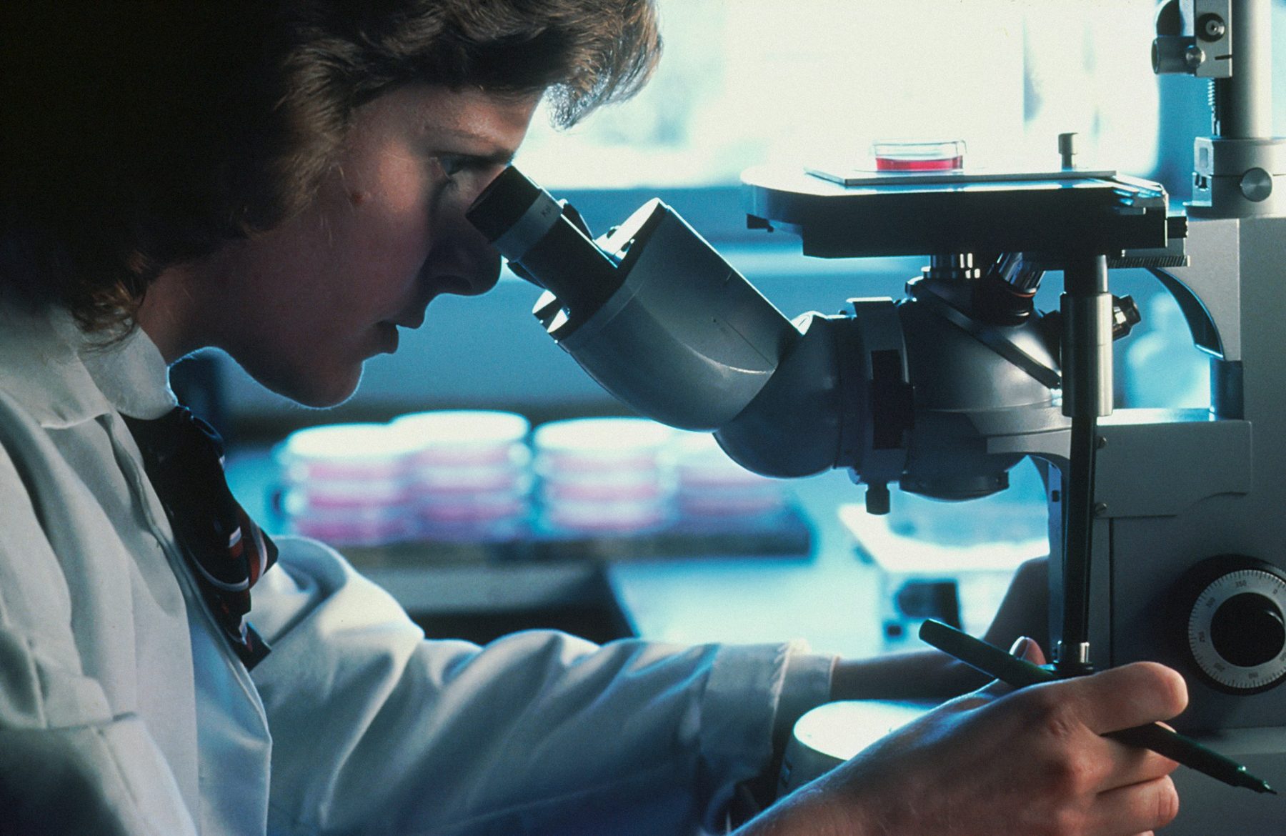 A scientist looking through a microscope
